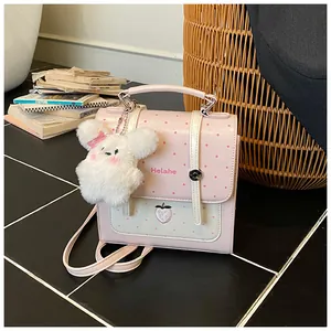 Sweet pink polka dot backpack featuring a plush bunny charm and strawberry detail.