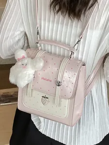 Pink polka dot backpack for women with strawberry embroidery and plush rabbit charm.