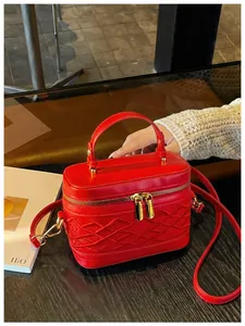 Minibolso caja rojo con elegantes detalles bordados expuesto en una mesa de madera