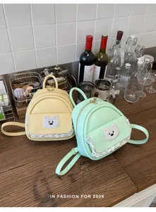 Two cute mini backpacks with bear patches and lace details on a wooden table