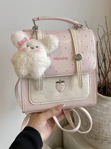 Stylish pink polka dot backpack featuring strawberry embroidery and a plush rabbit charm