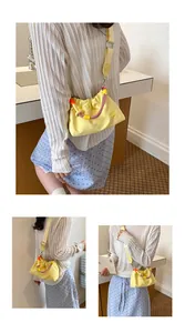 Mini sac bandoulière en nylon jaune avec poignée en corde tressée sur mannequin
