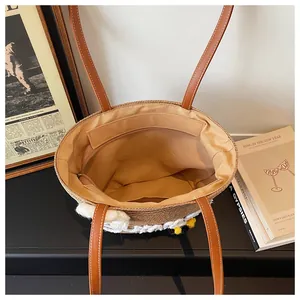 Top view of woven straw tote bag showing brown fabric lining and internal zipper pocket