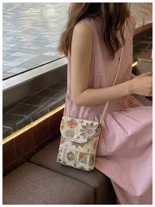 Vista dettagliata di una borsa a tracolla ricamata in stile New Chinese indossata da una modella
