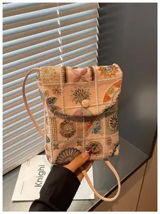 Dettaglio dell'intricato ricamo floreale su questa borsa per cellulare in stile cinese.