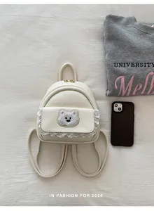 Detailed view of cream mini backpack with cute bear patch and lace trim detail