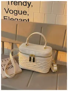 Vista detallada del bolso vanity box bordado blanco con doble cremallera dorada y asa
