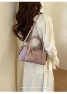 Detail shot of a purple lychee pattern bowling bag worn by a model in a minimal setting.