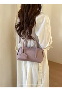 Close-up of a mauve litchi grain bowling bag shown as a stylish shoulder bag