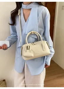 Elegant cream lychee pattern bowling bag shown on model with a matching mini charm bag.