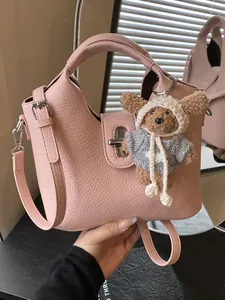 Rosa Handtasche aus geprägtem Leder mit niedlichem Bärenanhänger und Drehverschluss