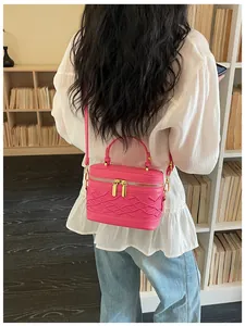 Mini bolso de caja rosa fucsia con detalles trenzados lucido por modelo en librería