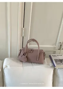 Minimalist dusty pink bowling bag with litchi texture shown in a lifestyle indoor setting