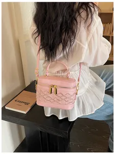 Detalle de estilo de vida de un mini bolso caja rosa con elegante bordado de celosía en modelo