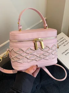 Elegante bolso de mano rosa tipo caja con patrón bordado blanco y herrajes dorados
