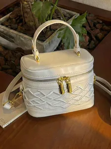 Elegante mini bolso de mano blanco crema con costuras de diseño y herrajes dorados