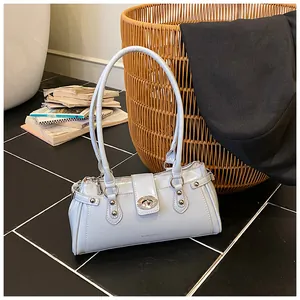 Vue détaillée d'un sac sous les bras vintage bleu clair avec serrure et clous en métal.