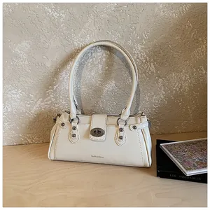 Vue détaillée d'un sac à bandoulière vintage crème avec un fermoir tournant métallique classique