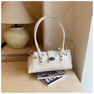 Gros plan d'un sac sous les bras crème sur des magazines de mode avec lampe chaude