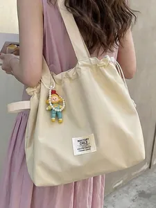 Large capacity off-white canvas tote bag with drawstring closure and doll charm decoration