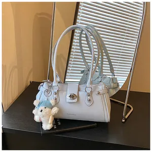 Sac à bandoulière vintage bleu clair avec charm ours blanc dans un cadre de style de vie