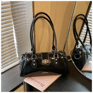 Détail d'un sac à bandoulière noir brillant rétro avec des accessoires argentés.