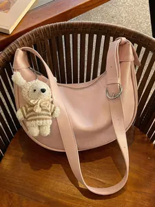 Elegant pink crescent crossbody dumpling bag featuring a cute plush rabbit charm