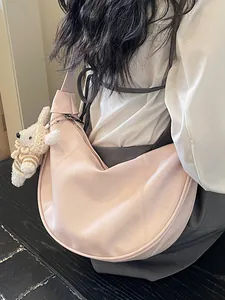 Elegant minimalist pink leather hobo bag with cute knitted charm for stylish daily wear.