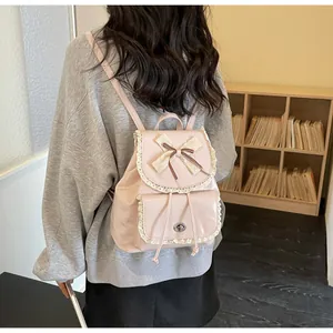 Back view of a chic pink women's backpack with lace trim and bow detail in a cozy setting