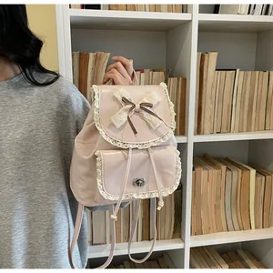 Close-up of elegant pink backpack for women featuring lace trim and a cute bow ornament.