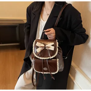 Stylish brown synthetic leather backpack with delicate lace trim and ribbon bow decoration