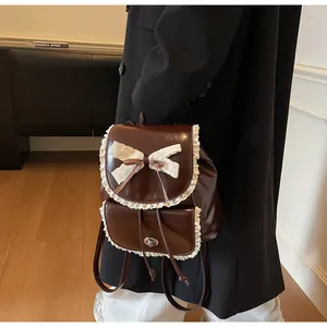 Detail of a brown leather backpack with elegant lace trim and a white bow decoration