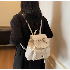 Back view of a woman wearing an elegant off-white lace bow backpack with a black coat.