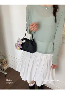 Elegante bolso de cubo de cuero negro fruncido para mujer con un lindo dije de peluche.