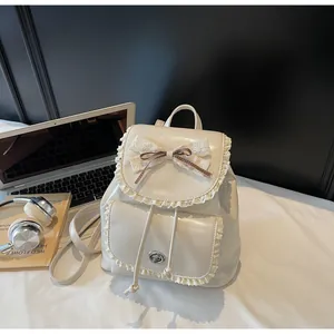 Refined creamy white women's backpack with lace trim and bow in a stylish study scene layout