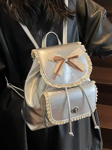 Elegant silver metallic backpack featuring vintage lace trim and a delicate bow detail