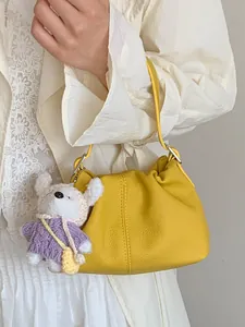 Elegante bolso bombonera de cuero amarillo brillante con lindo colgante de osito para mujer