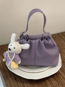 Elegante bolso bombonera de cuero texturizado morado con diseño plisado y conejo