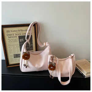 Two sizes of stylish pink faux leather shoulder bags with cute fuzzy doll accessories