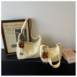 Comparison of large and small off-white crossbody bags with fuzzy monster keychains