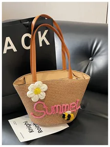 Close-up detail of a handmade straw beach tote with pink Summer embroidery and flowers