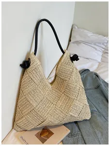 Grand sac cabas en paille tressé à la main pour les vacances à la plage, détail lifestyle