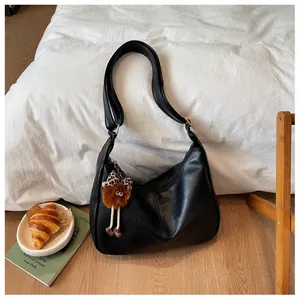 Close-up of a stylish black large-capacity hobo bag with a cute plush charm