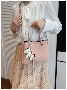 Detail view of a pink fashion bucket bag featuring an adjustable strap and cute horse charm.
