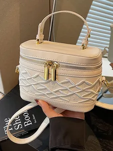 Mini bolso de mano color crema con bordado de celosía elegante y herrajes dorados
