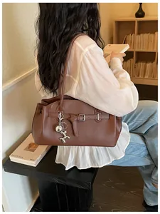 Brown pebbled leather shoulder bag for women with a cute silver balloon dog charm