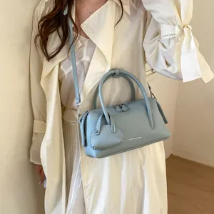 Elegant light blue litchi grain bowling bag with dual handles and crossbody strap