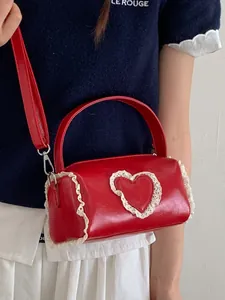 Elegant red mini cylindrical handbag with a delicate lace heart detail and shoulder strap