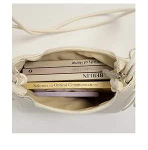 Detailansicht des geräumigen Innenraums dieser cremefarbenen minimalistischen Achseltasche