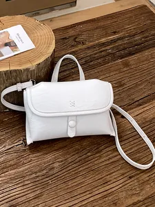 Chique minimalistische witte getextureerde kleine crossbodytas voor dames op hout